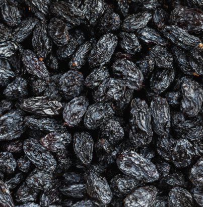 Black Raisin texture, popular dried fruit. Dried grapes. Red seedless raisins from grapes
