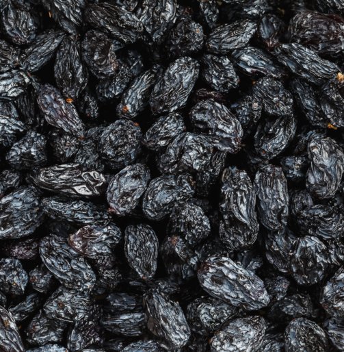 Black Raisin texture, popular dried fruit. Dried grapes. Red seedless raisins from grapes