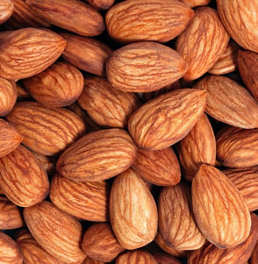 Background of almonds. Fried almonds. Scattered almond grains. Background for advertising, layout, mockup.