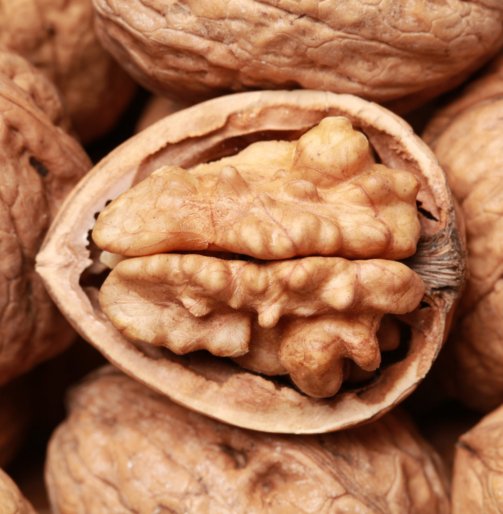 Walnuts in shells, one upon the other, one nut is open